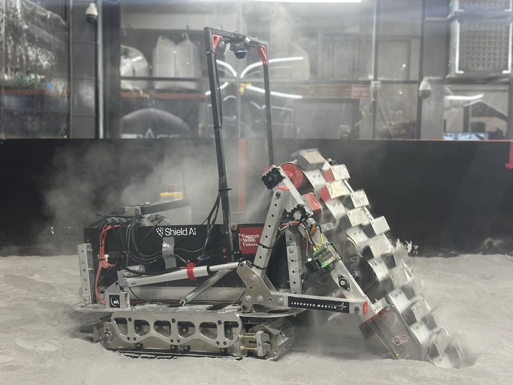 The rover digging regolith in the Lunabotics competition arena